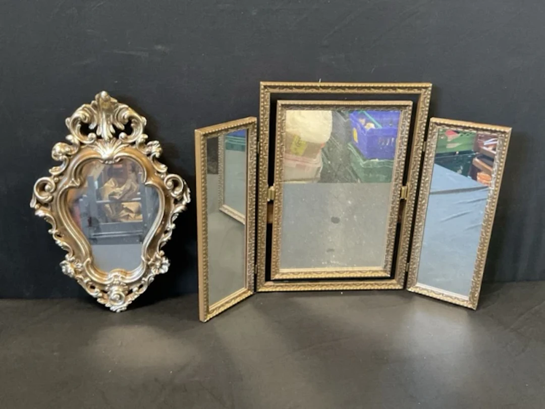 A baroque style silvered plaster cartouche shaped mirror with flowerhead