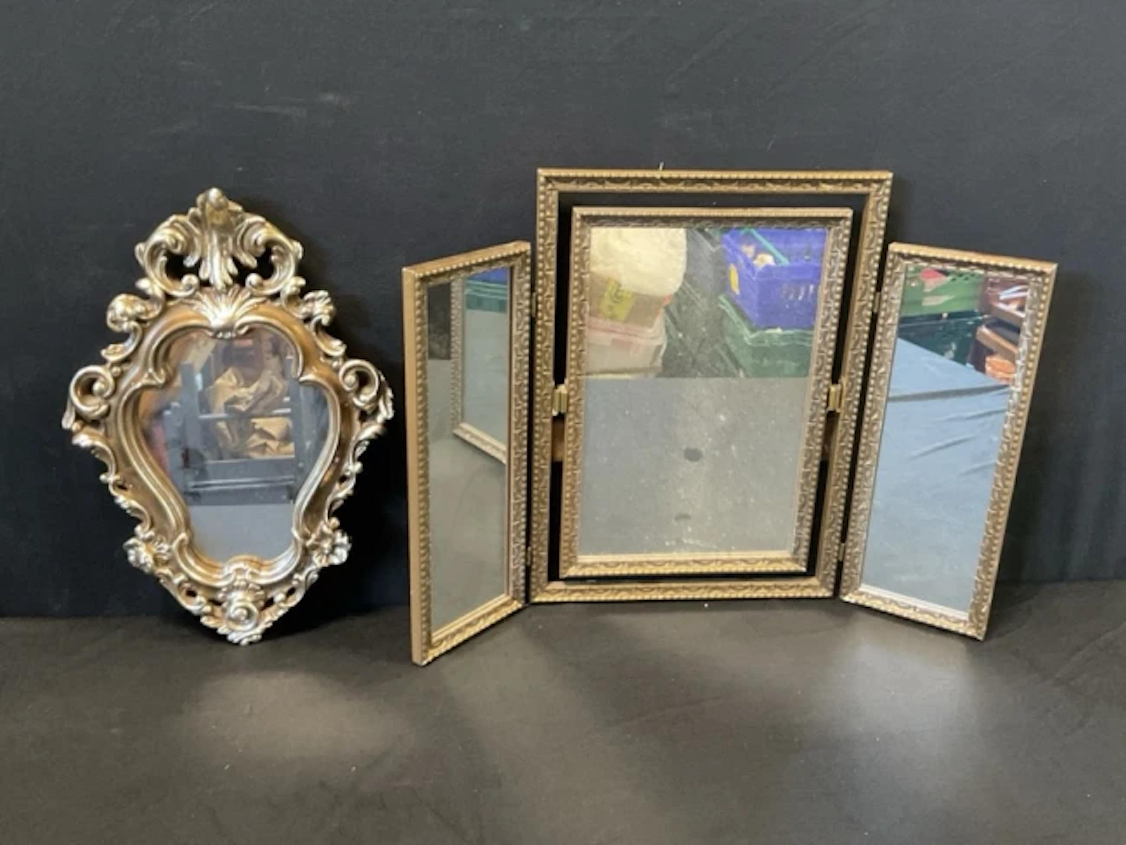 A baroque style silvered plaster cartouche shaped mirror with flowerhead