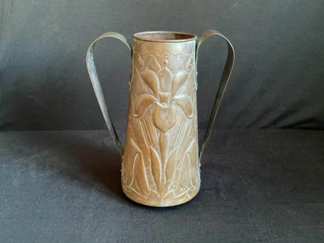 An art nouveau Newlyn tapering embossed copper vase with twin relief
