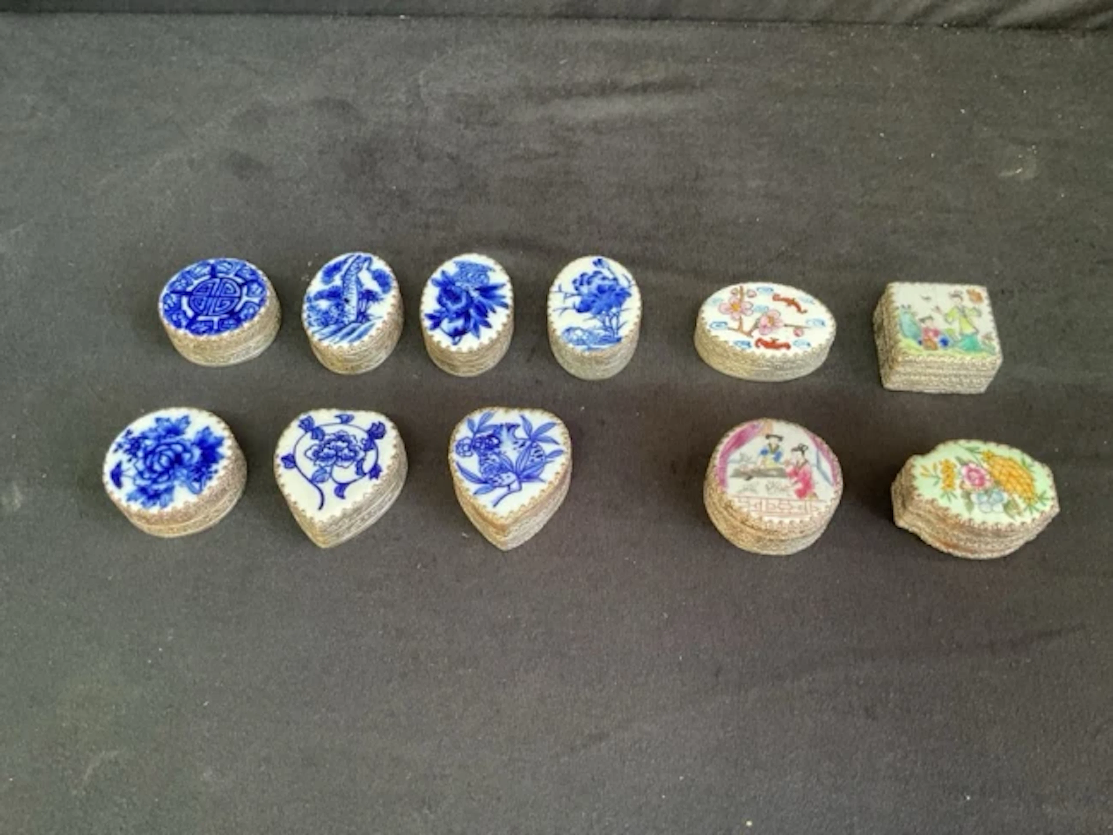 Eleven Chinese silver plated pillboxes, the covers made from fragments