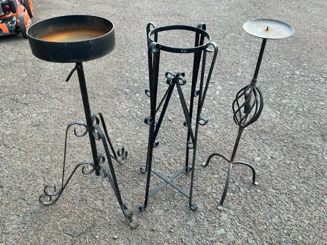 A wrought iron jardinière stand with circular dish on scrolled support