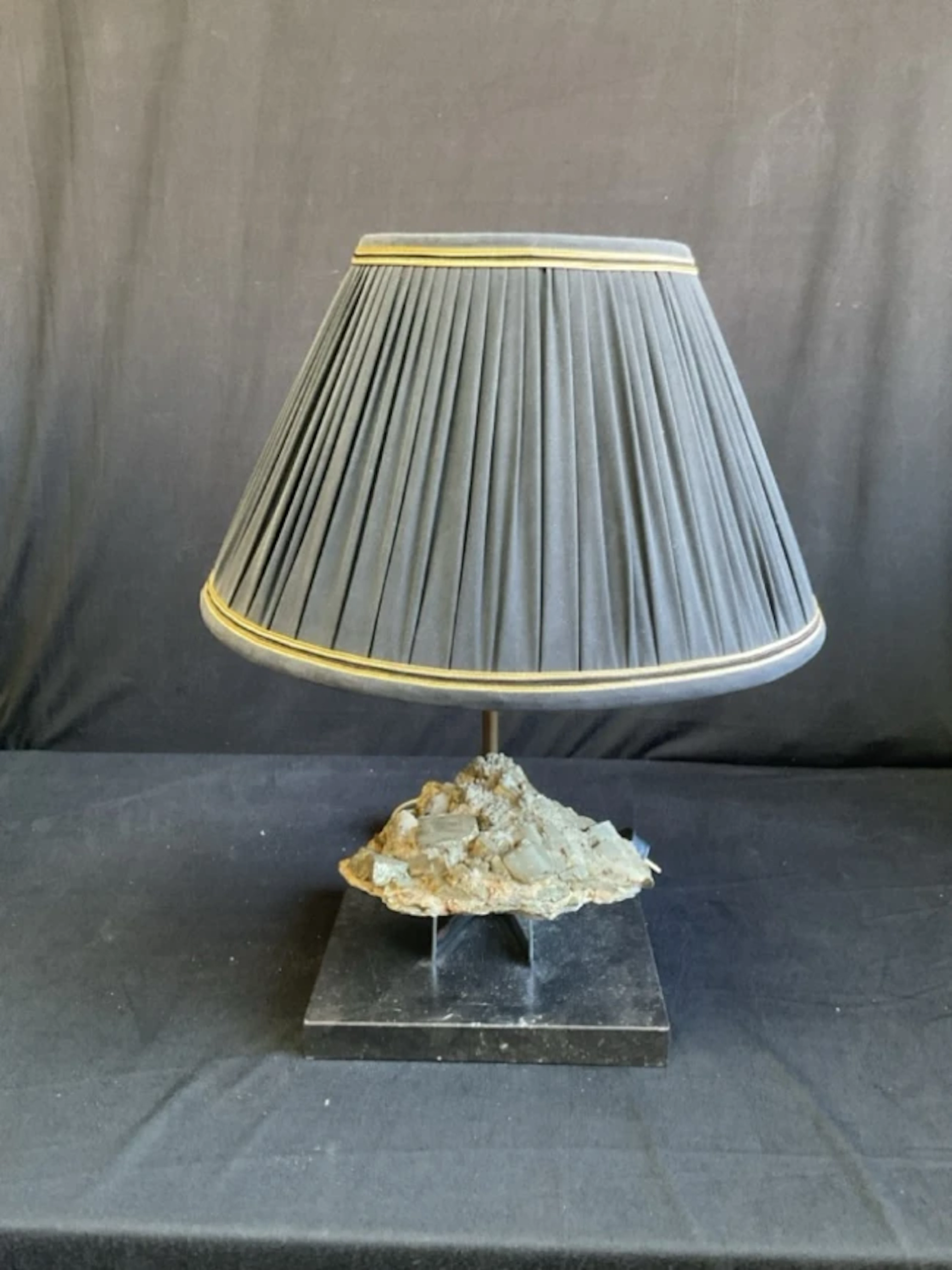 A contemporary tablelamp with pleated cotton shade on an offset tubular