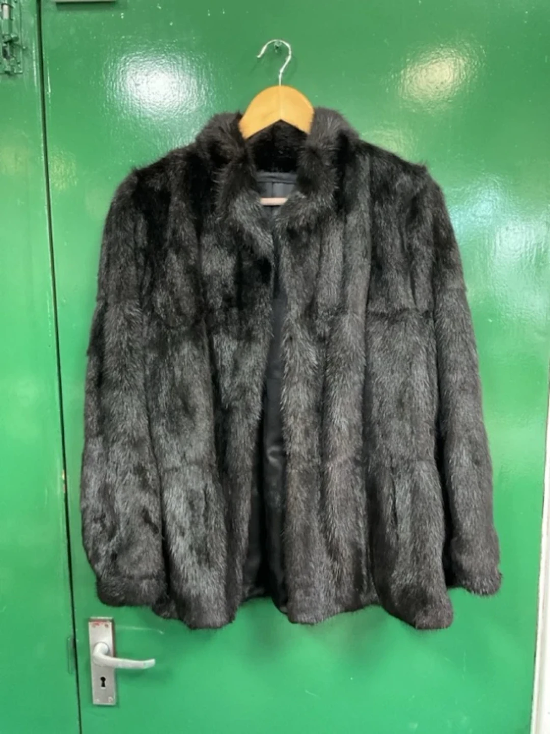 A black mink fur jacket with rolled collar and floral brocaded satin lining.