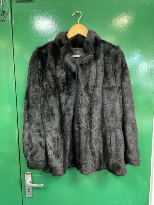 A black mink fur jacket with rolled collar and floral brocaded satin lining.
