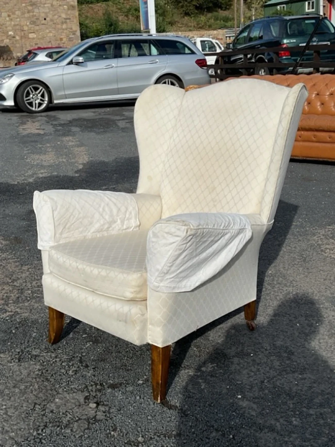 A mid-century upholstered wing armchair with arched back and seat