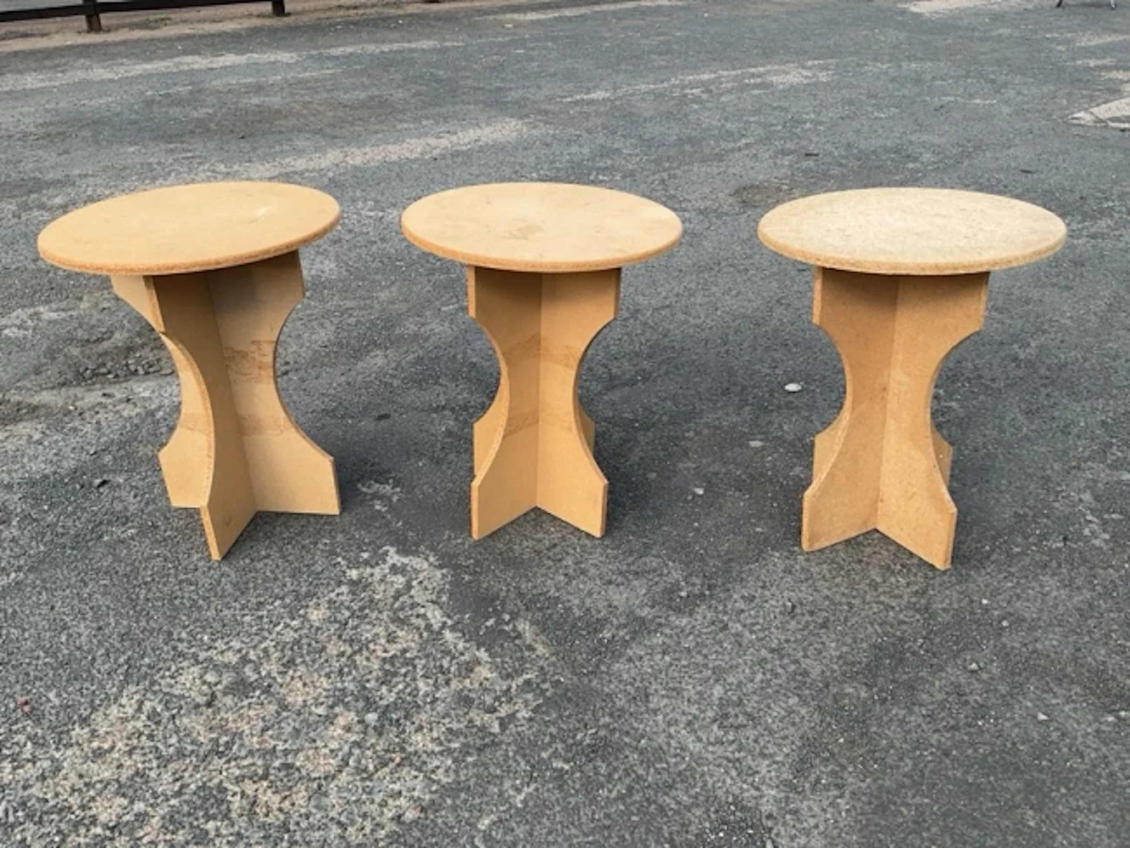 Three chipboard occasional tables with circular tops on waisted cruciform