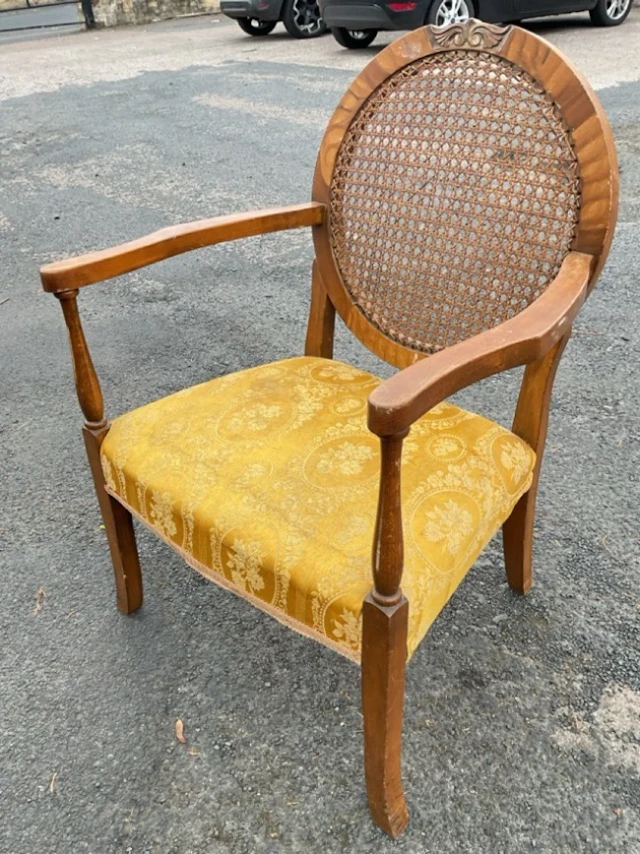 A C20th armchair with circular caned back in faux walnut scroll carved