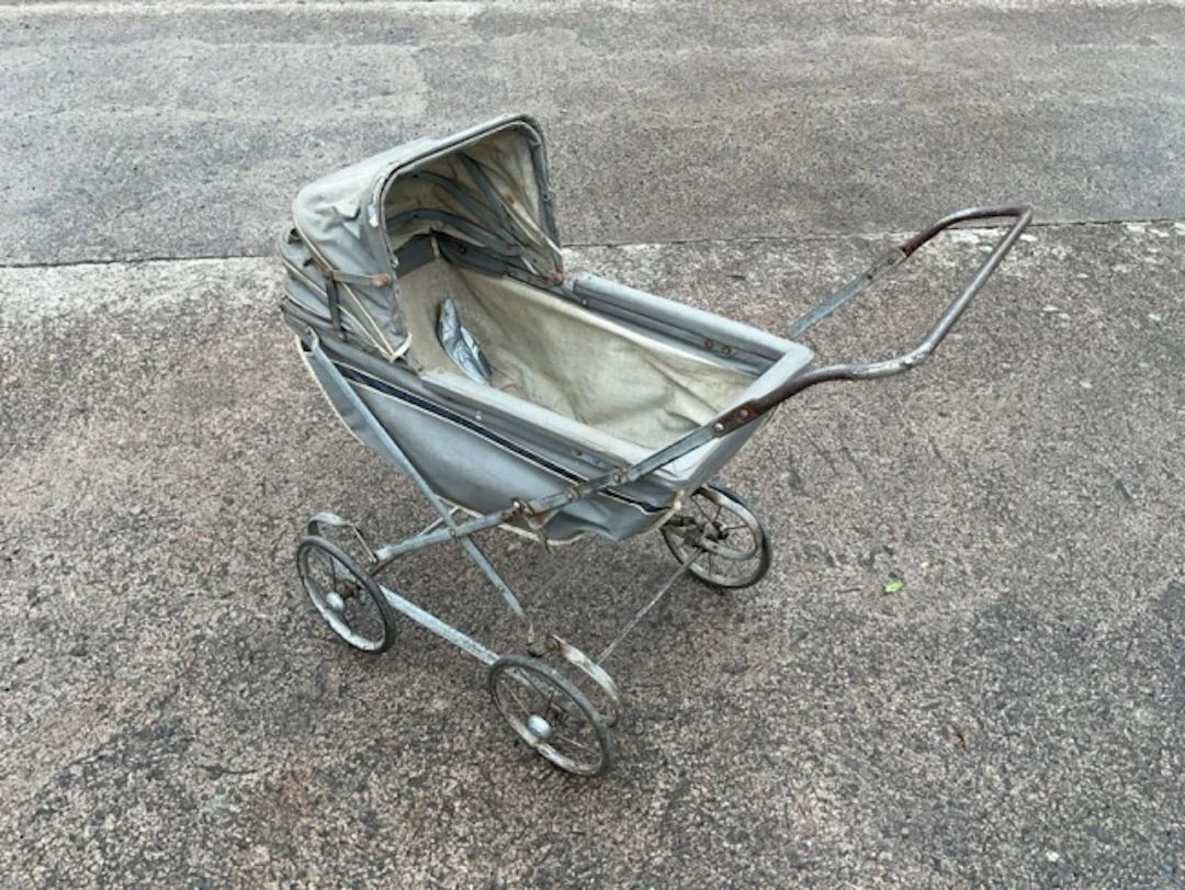 A 60s collapsible toy pram with concertina hood to fabric lined cradle