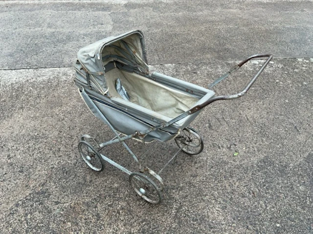 A 60s collapsible toy pram with concertina hood to fabric lined cradle