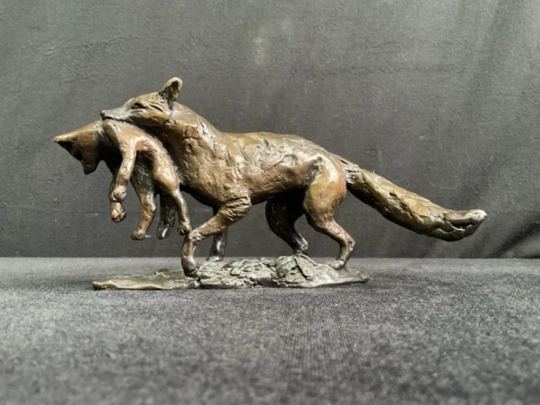 Linda Frances, light brown patinated bronze, figure of a vixen carrying