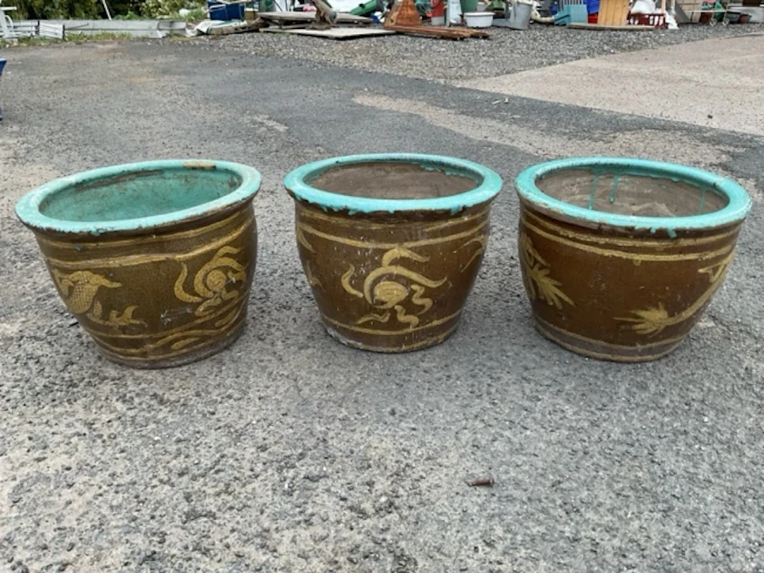 A set of three stoneware garden pots with turquoise glazed moulded