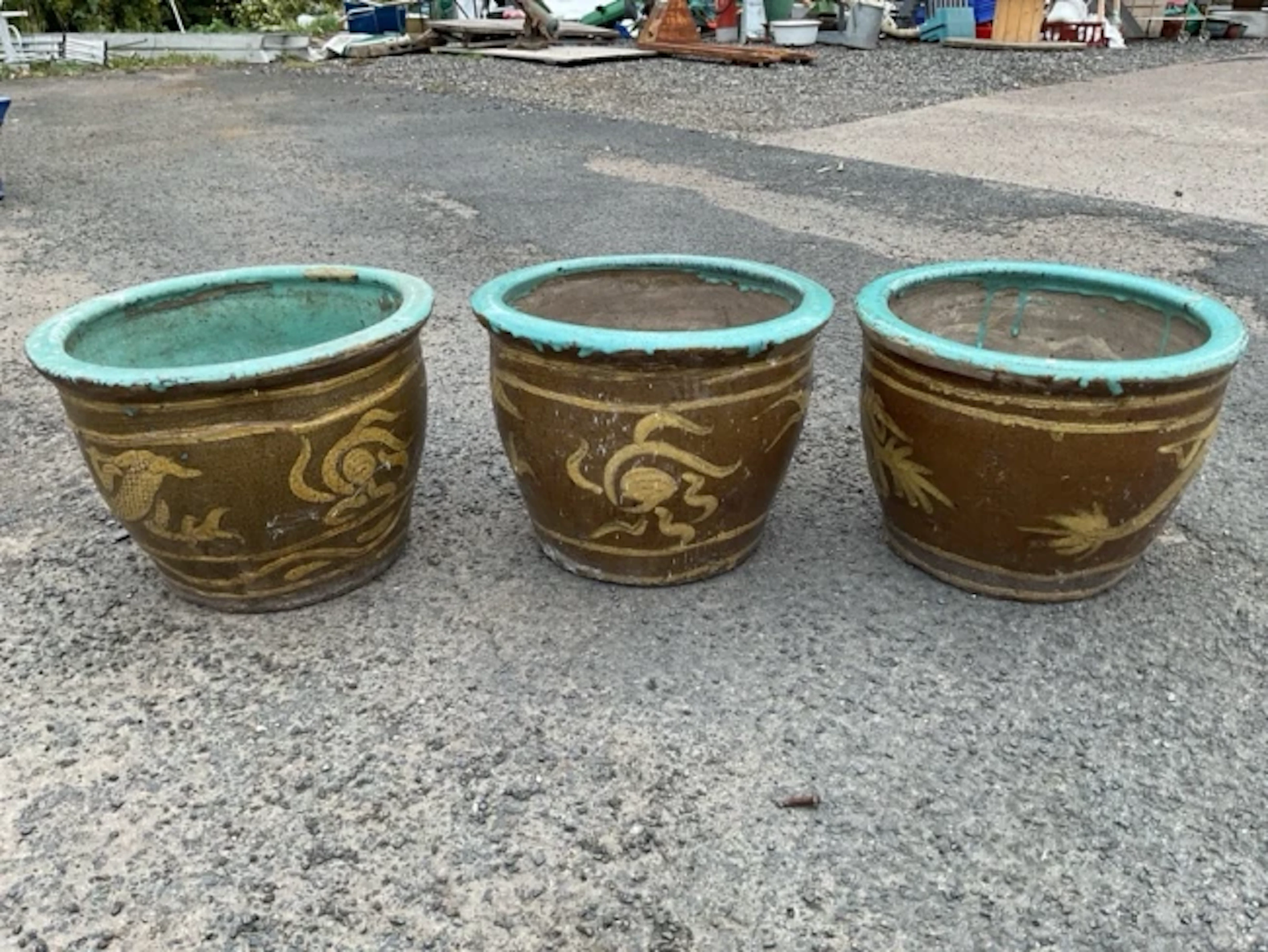 A set of three stoneware garden pots with turquoise glazed moulded