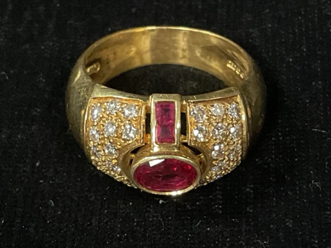 A mens 18ct gold ring with oval cut and channel set rubies flanked