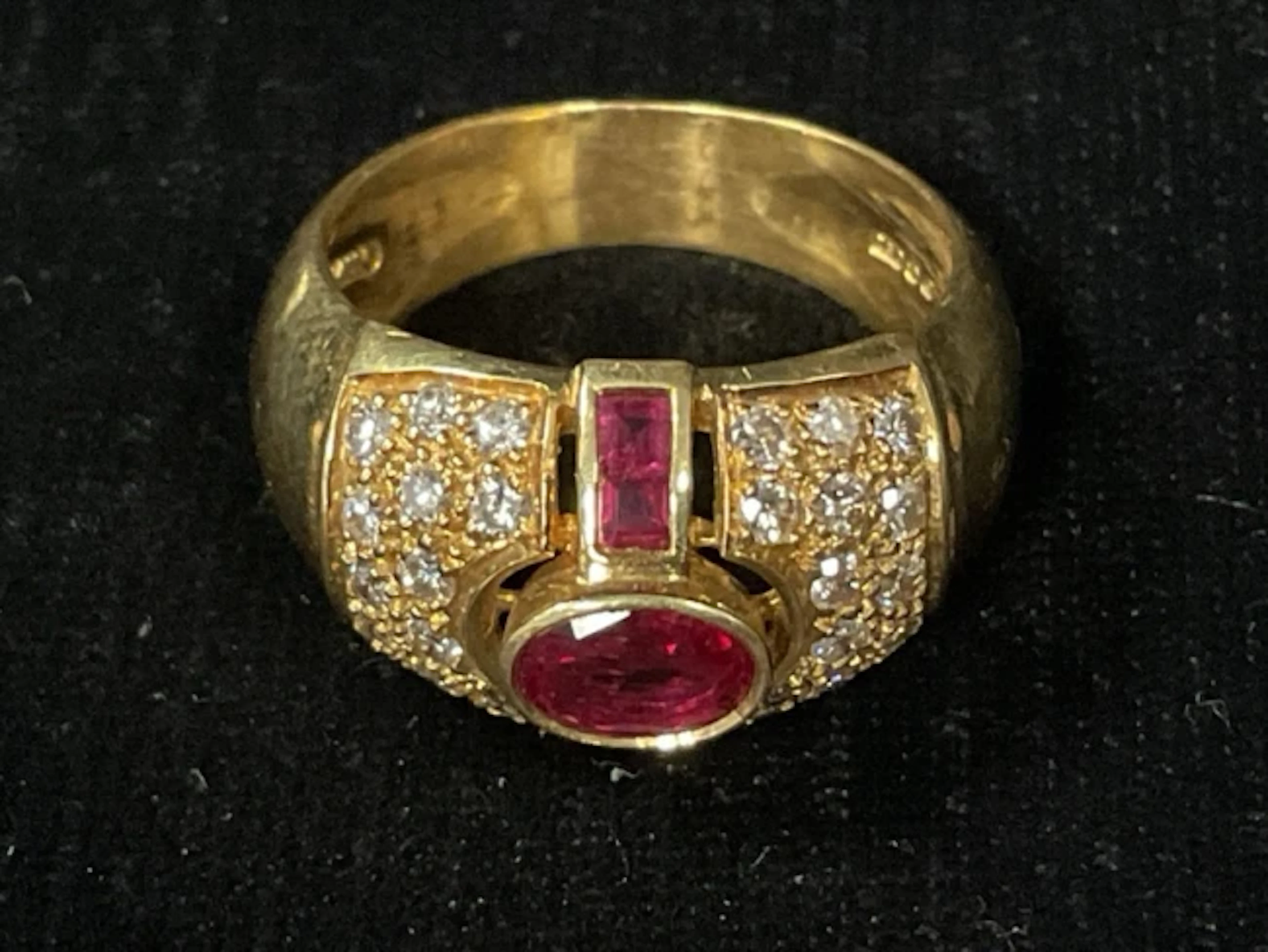 A mens 18ct gold ring with oval cut and channel set rubies flanked