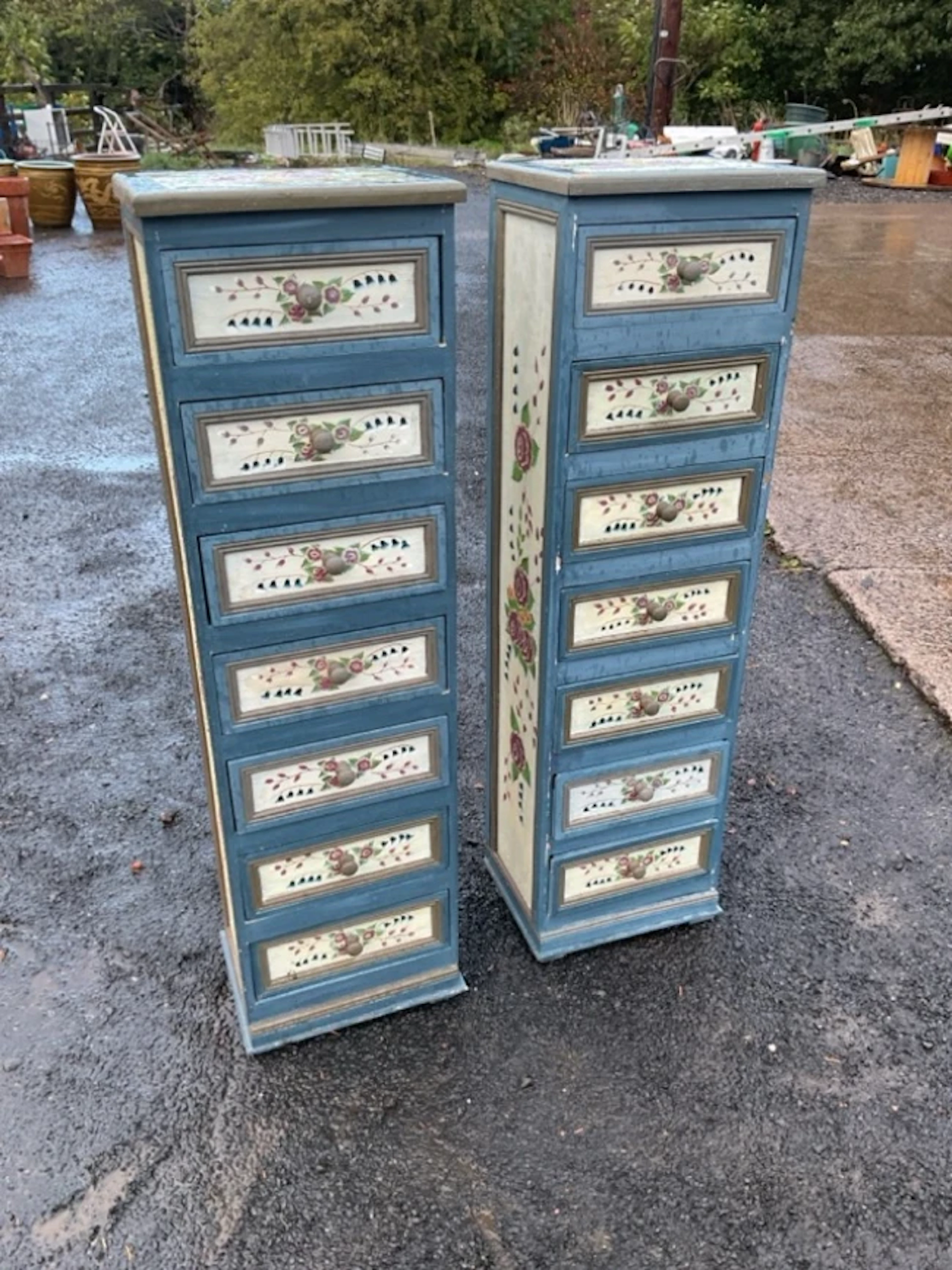 A pair of floral painted tower cabinets, each containing seven panelled