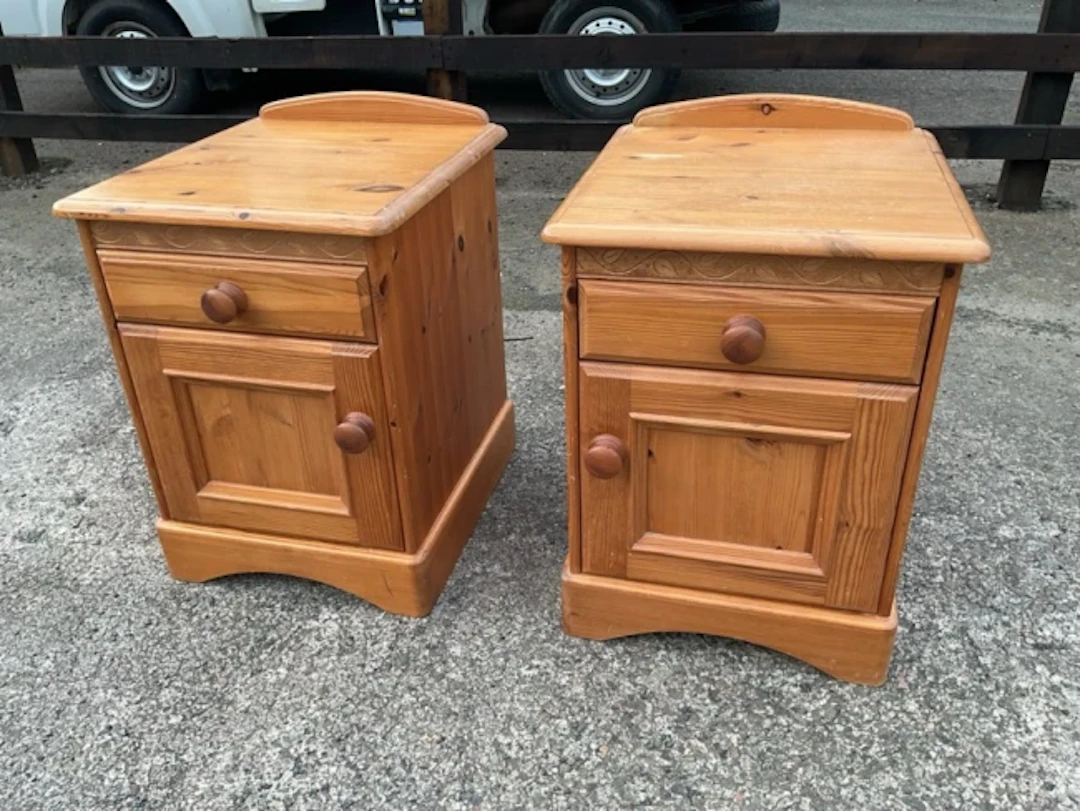 A pair of pine bedside cabinets with moulded tops above knobbed drawers