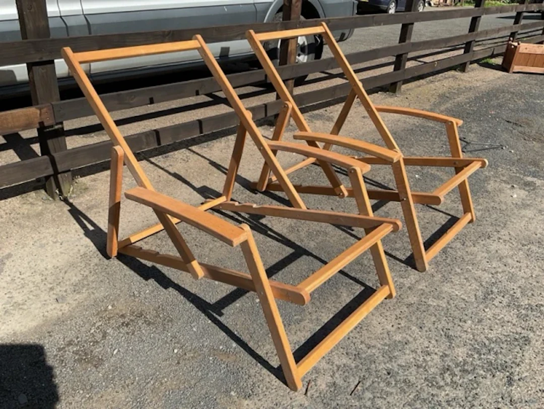 A pair of folding beech deck-type armchairs with adjustable ratchet