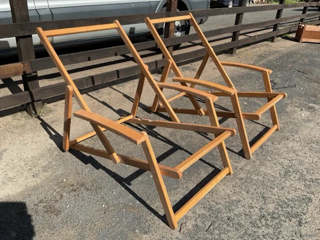 A pair of folding beech deck-type armchairs with adjustable ratchet