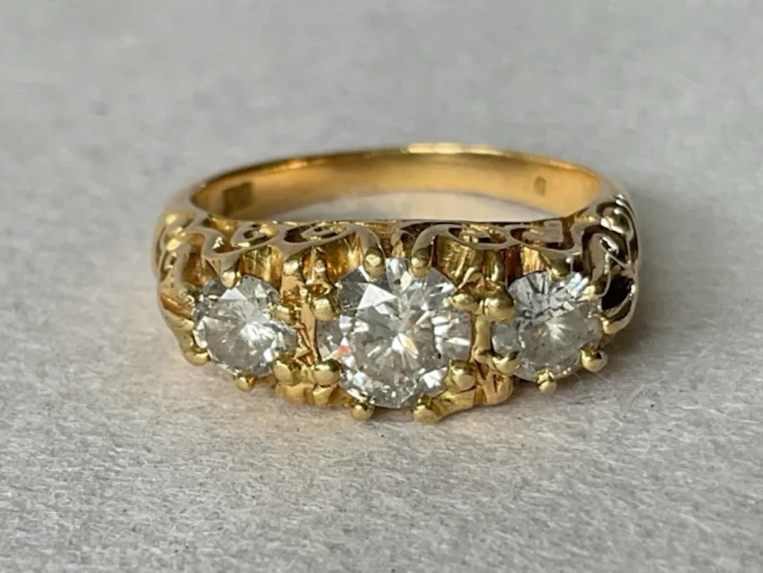 An antique 18ct gold diamond trilogy ring having three brilliant cut
