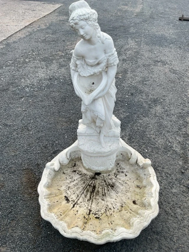 A painted composition stone garden water feature modelled as the lady