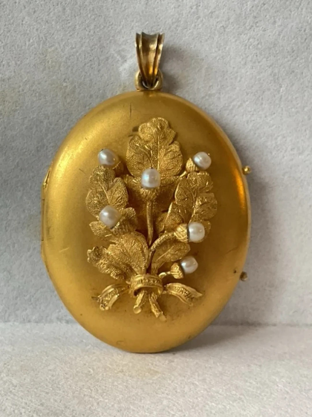 A Victorian 15ct gold locket with oak leaf and pearl set acorns to