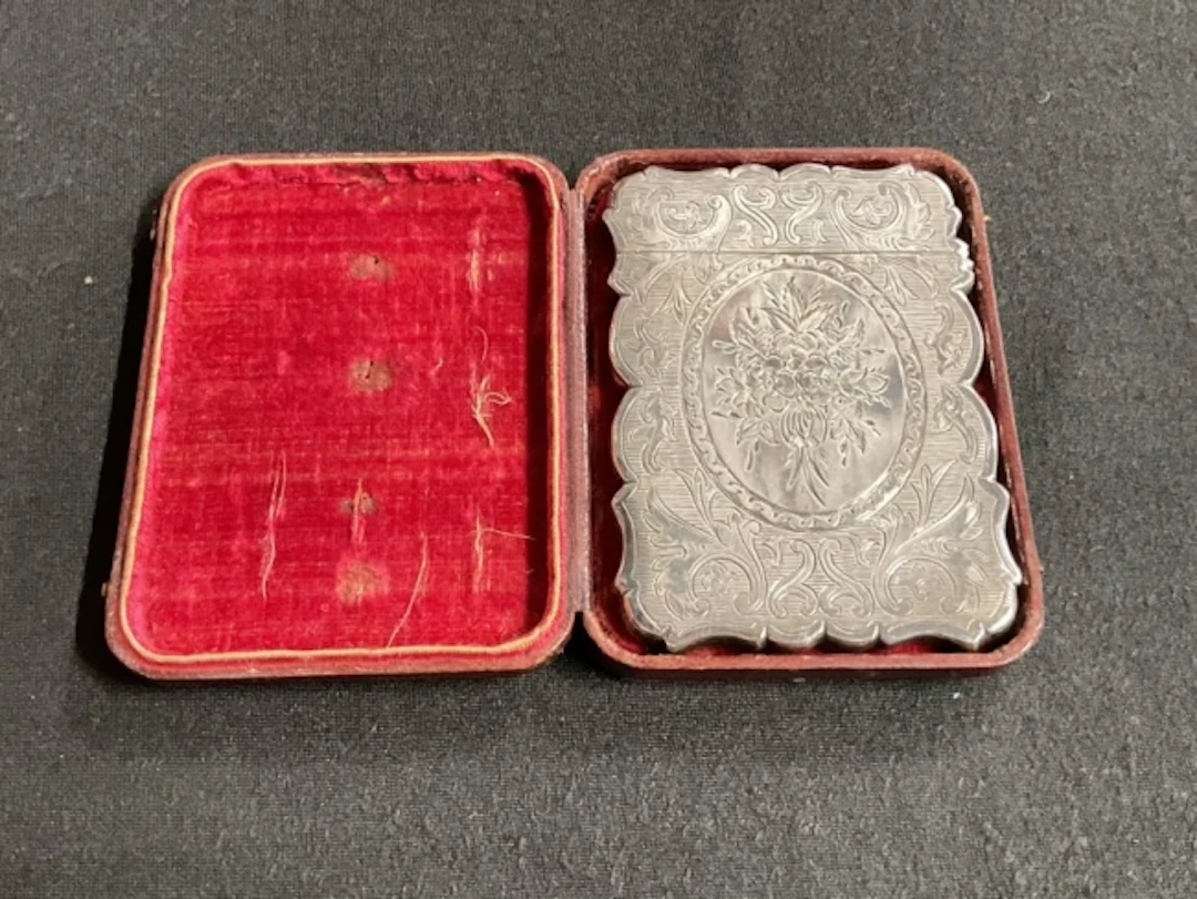 A Victorian leather cased rectangular unmarked white metal card case