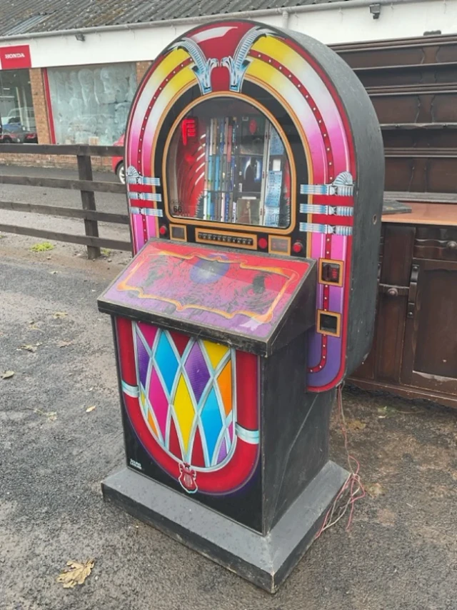 A 1980s CD jukebox box with colourful arched frame displaying the
