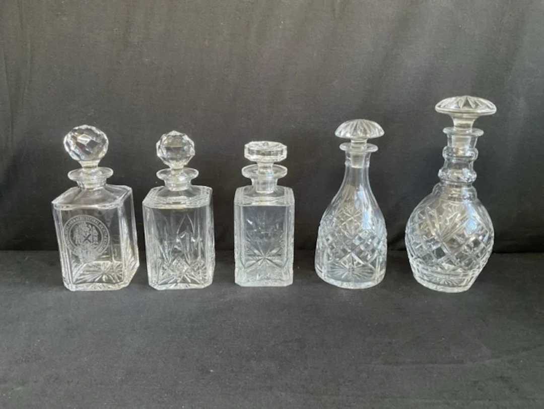 Three square cut glass decanters & stoppers with chamfered corners