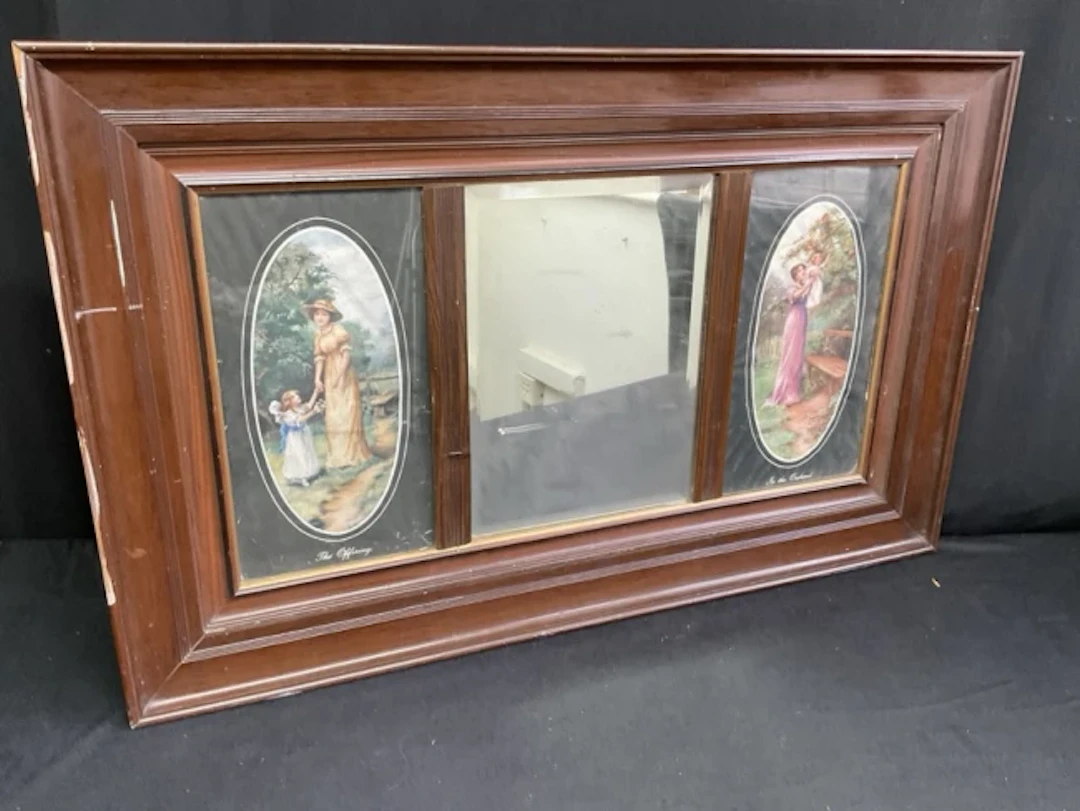 An Edwardian faux walnut wall mirror with rectangular bevelled plate