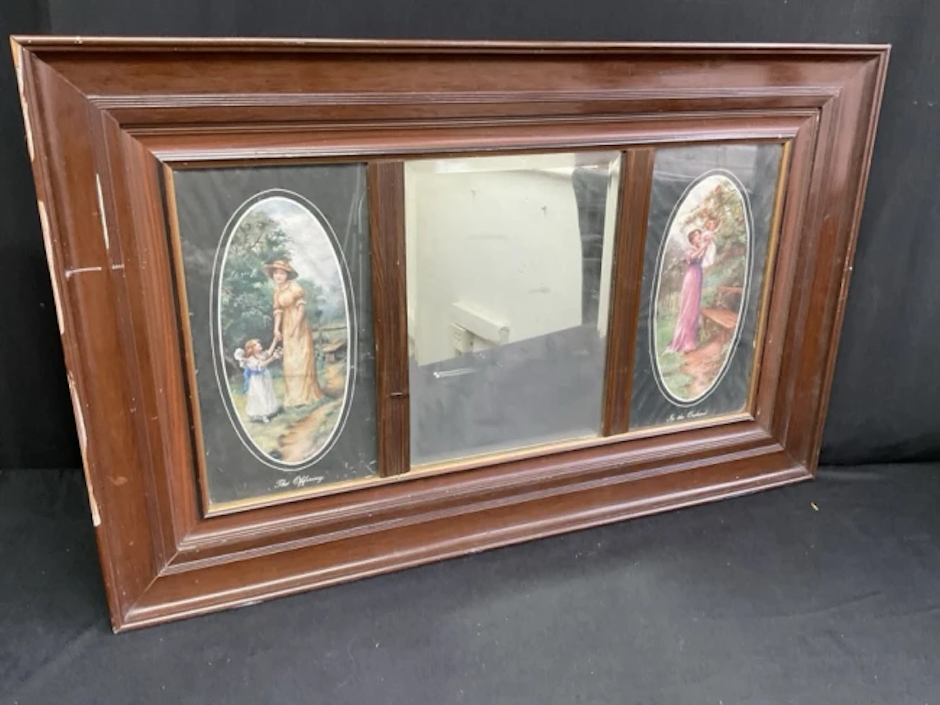 An Edwardian faux walnut wall mirror with rectangular bevelled plate