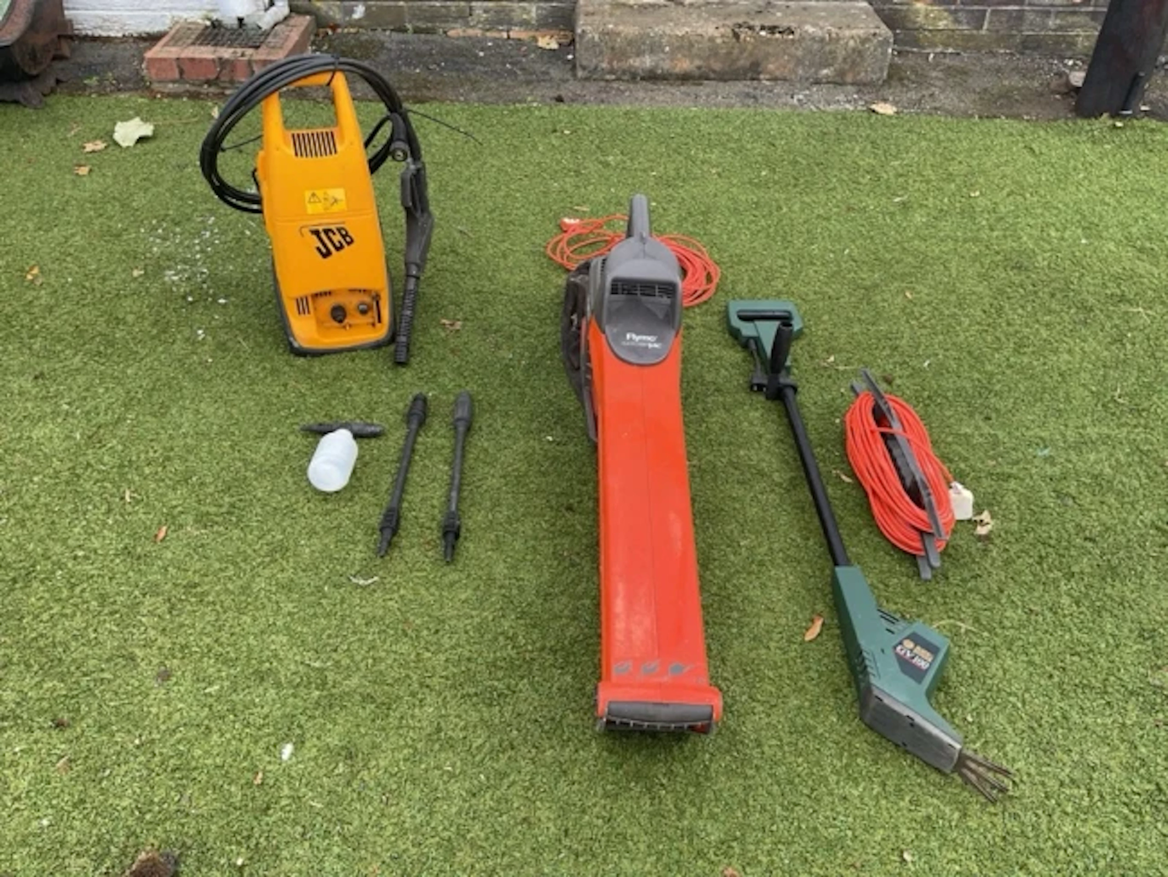 An electric Flymo garden vac with fabric collection bag; a JCB electric