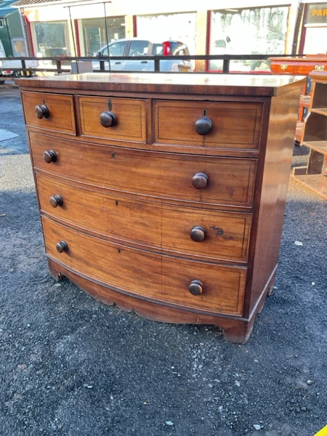 A nineteenth century bowfronted mahogany chest of three short and