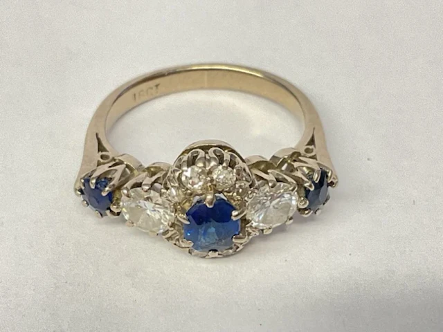 An 18ct white gold sapphire and diamond ring, claw set with trilogy