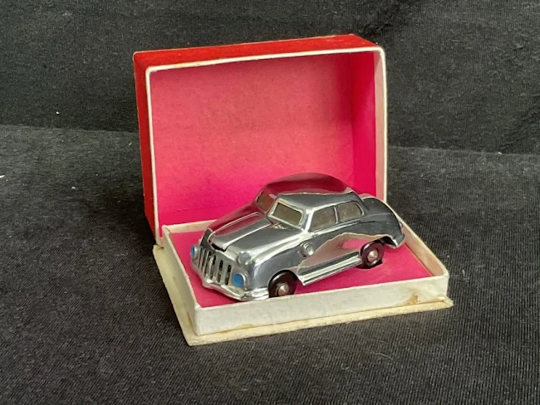A boxed SNE Occupied Japan chromed Lucky Car novelty lighter. (2.75in)