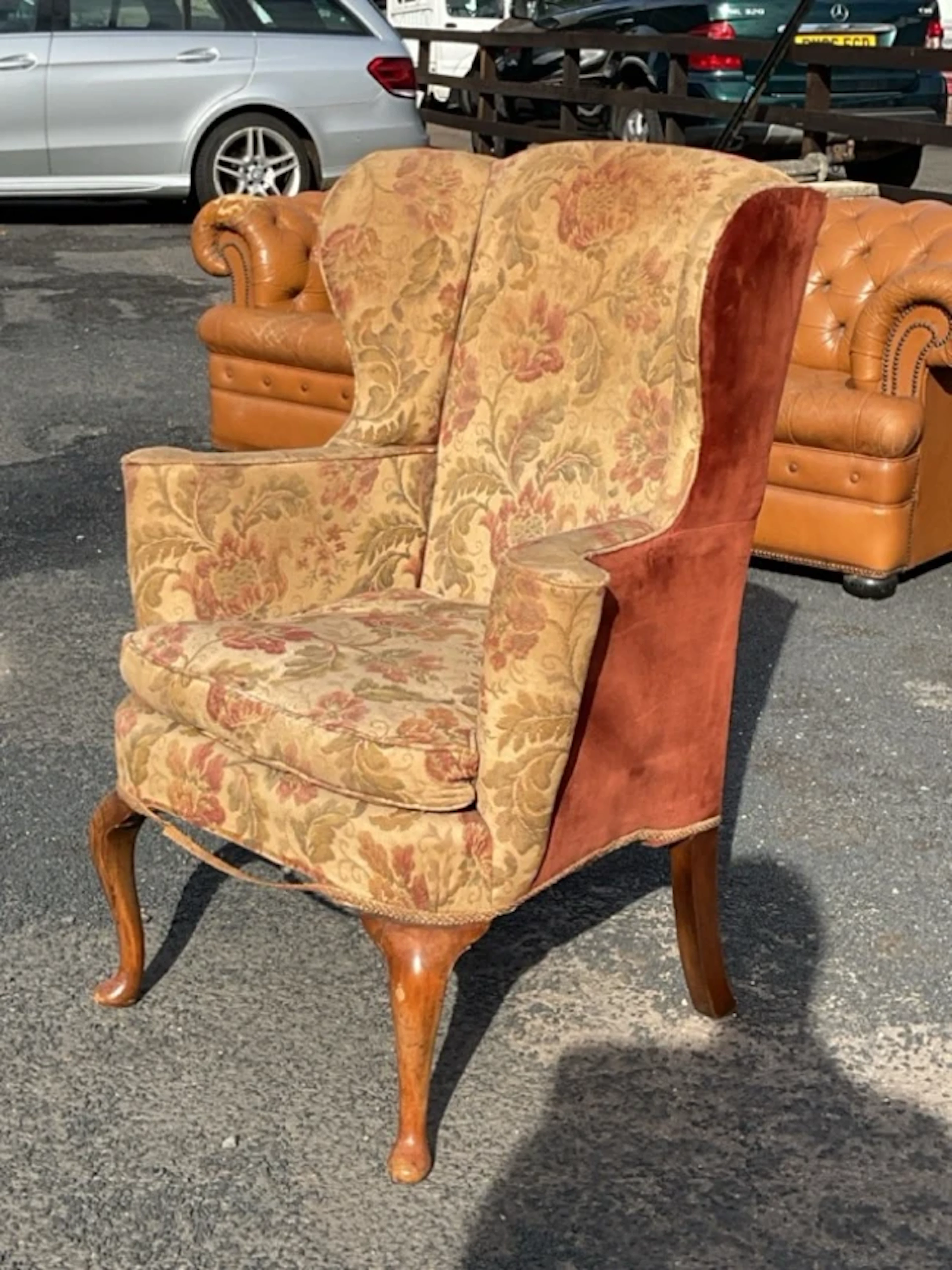A Queen Anne style upholstered wing armchair with arched back and