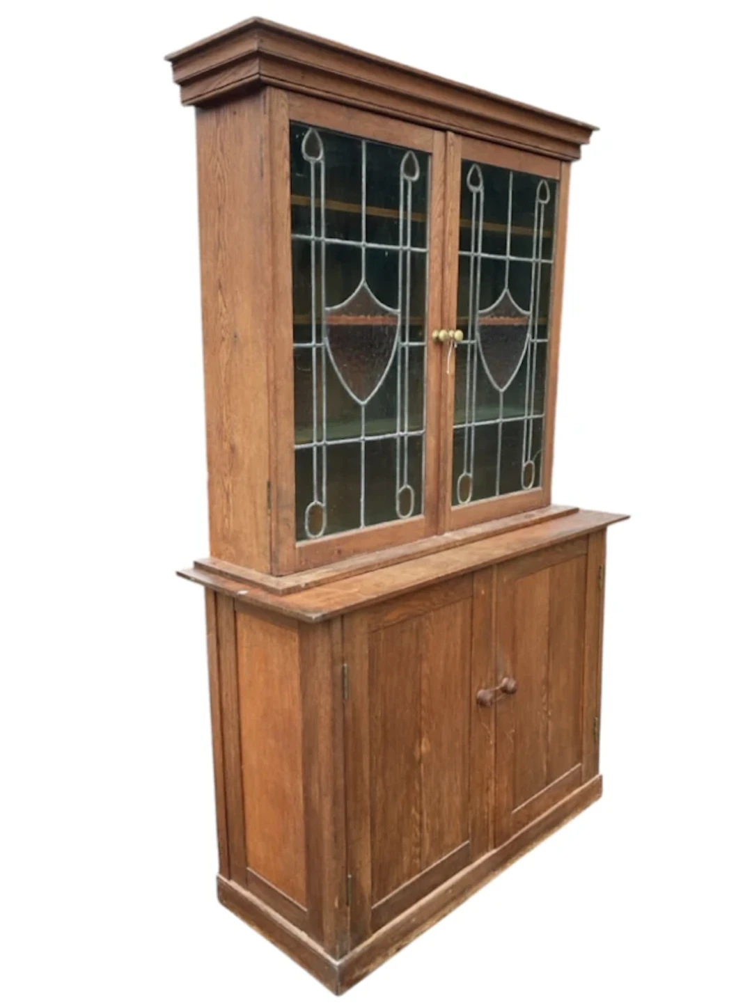 An art nouveau oak cabinet with moulded cornice above leaded stained