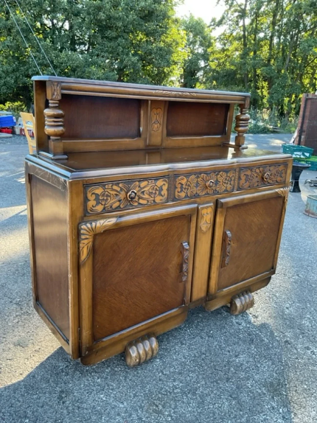 A 30s carved oak sideboard, the bowfronted shelf on turned supports