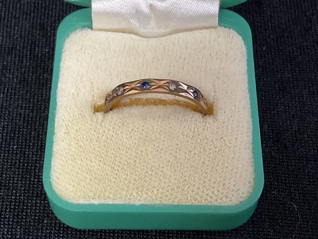 A hallmarked 9ct gold, sapphire and zircon eternity ring - size N. (1.3g)