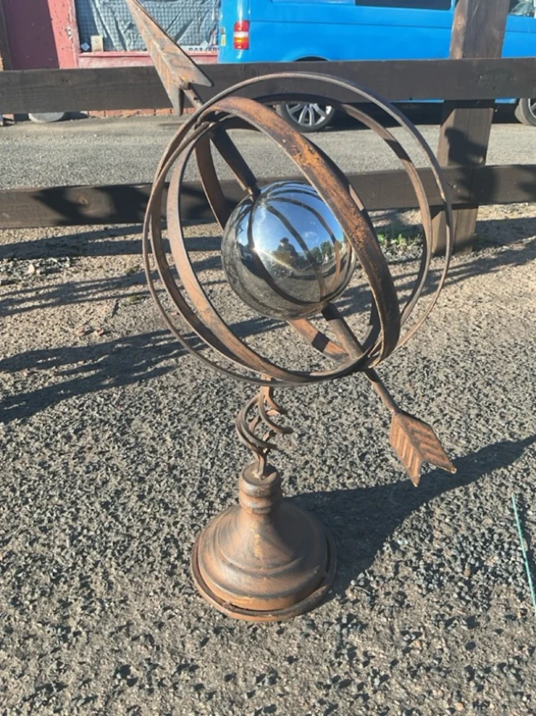 A metal armillary sphere with lathe formed globe pierced by an arrow