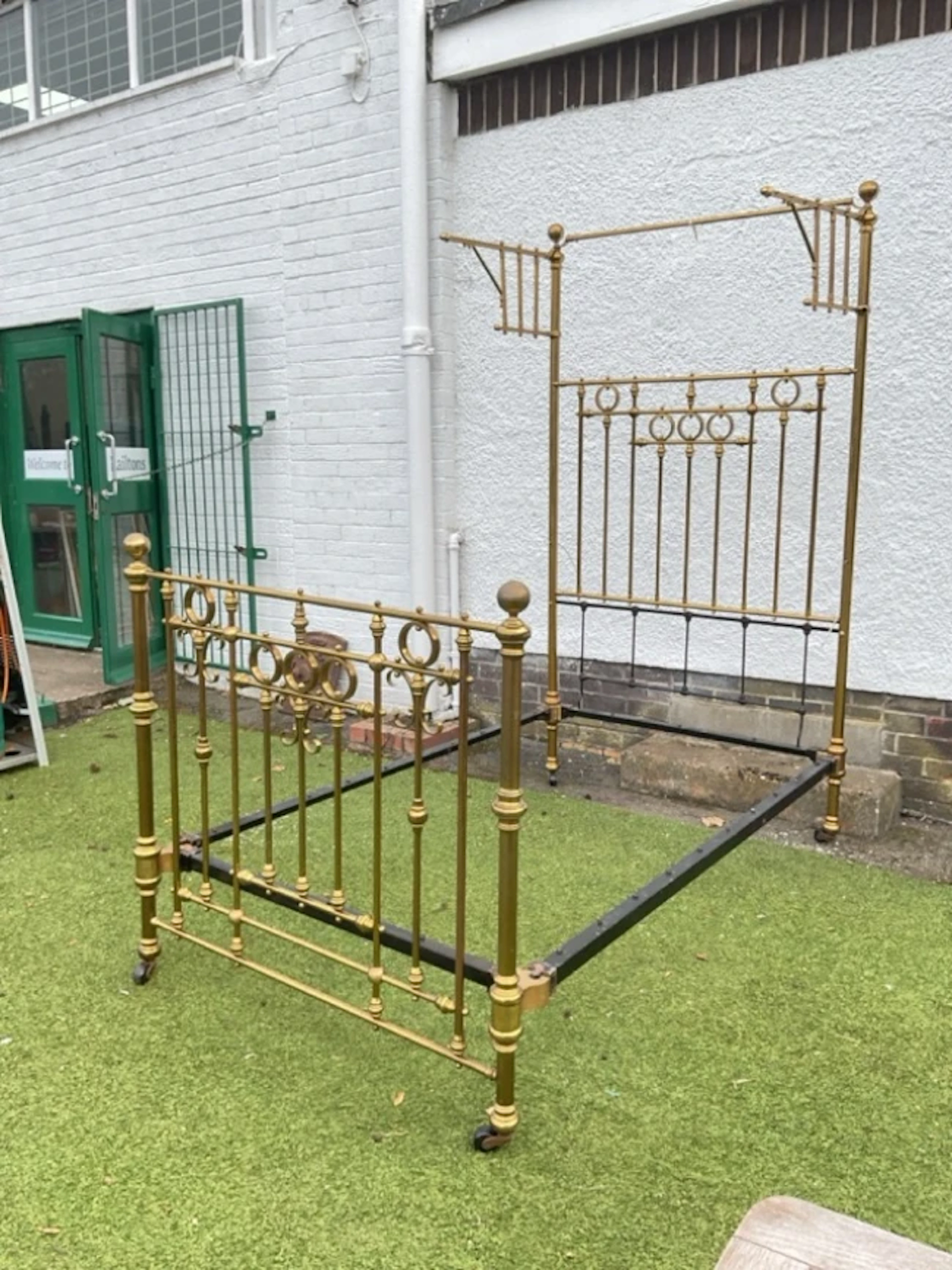 A Victorian brass half-tester bed, the tall headboard with hinged