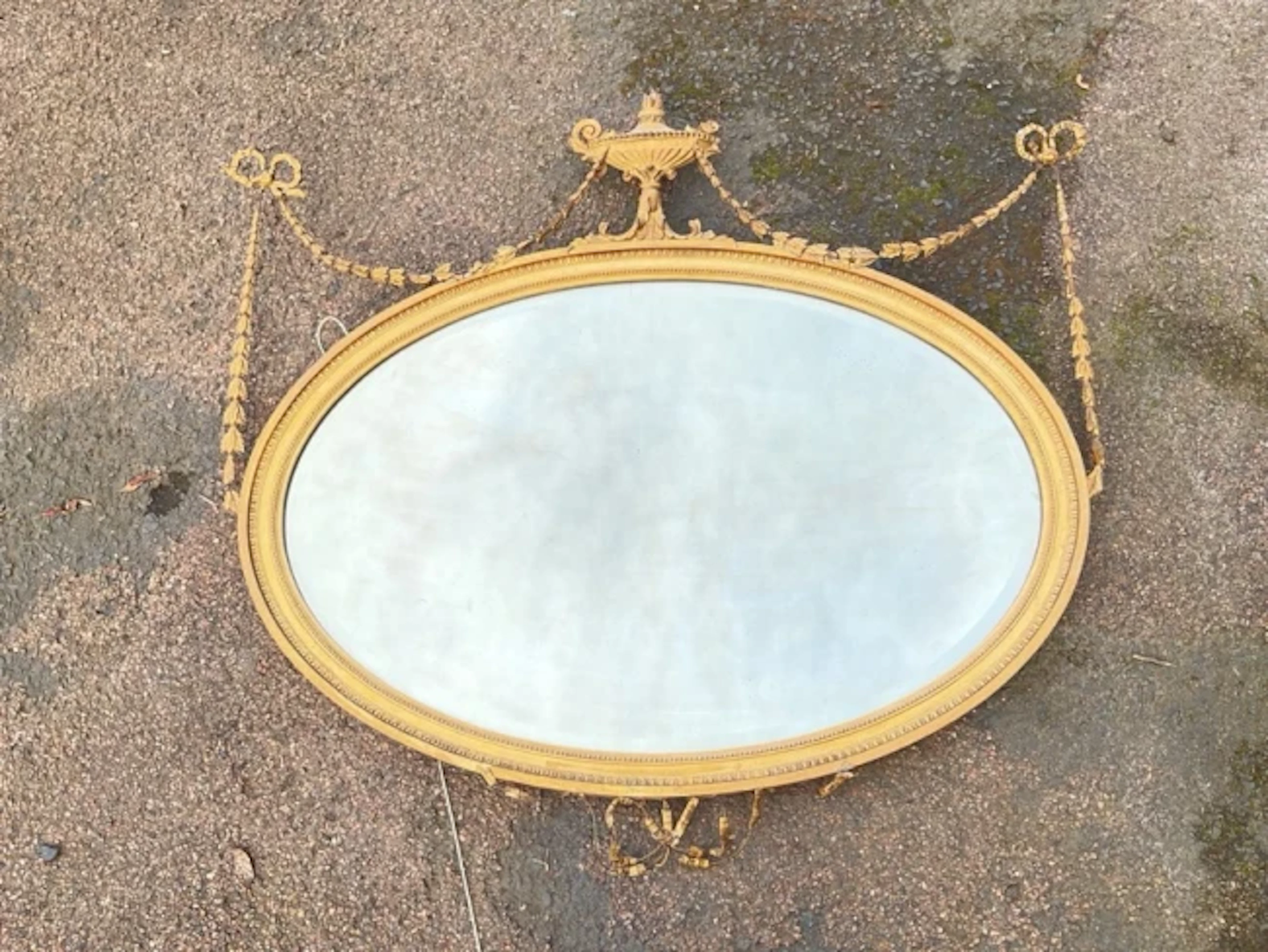 A nineteenth century Adams style oval mirror with bevelled plate in
