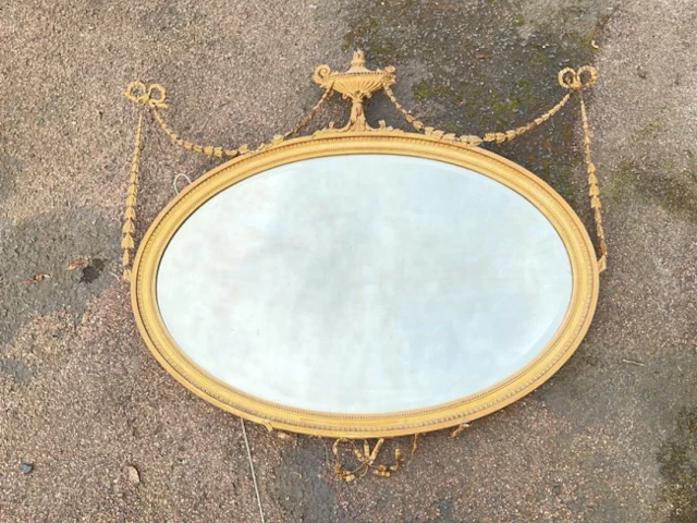 A nineteenth century Adams style oval mirror with bevelled plate in