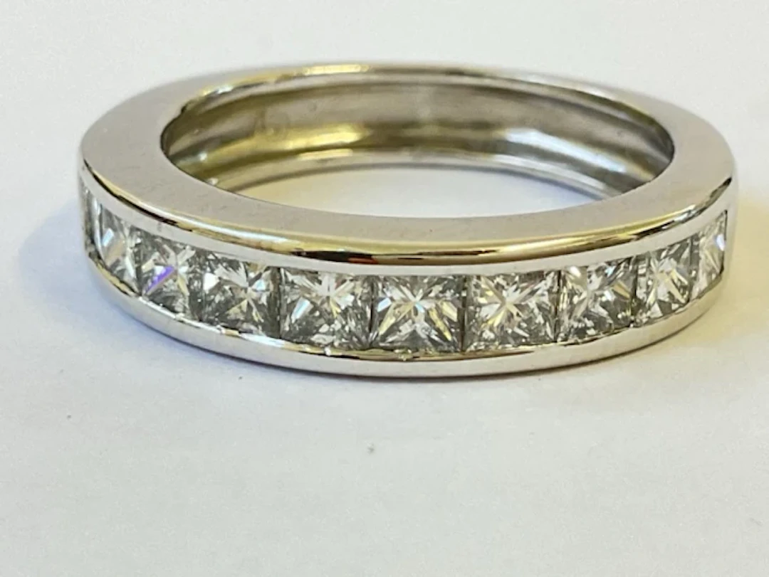 An 18ct white gold half eternity ring channel set with 10 square cut