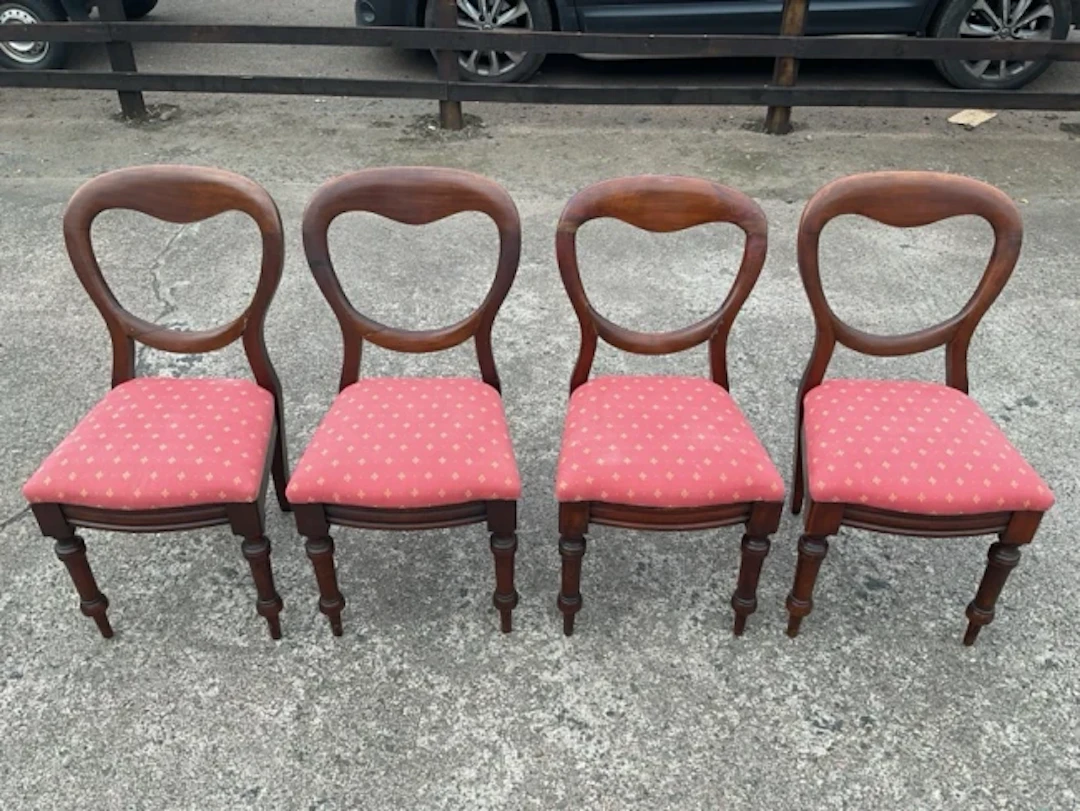 A set of four mahogany balloon-back dining chairs with drop-in upholstered