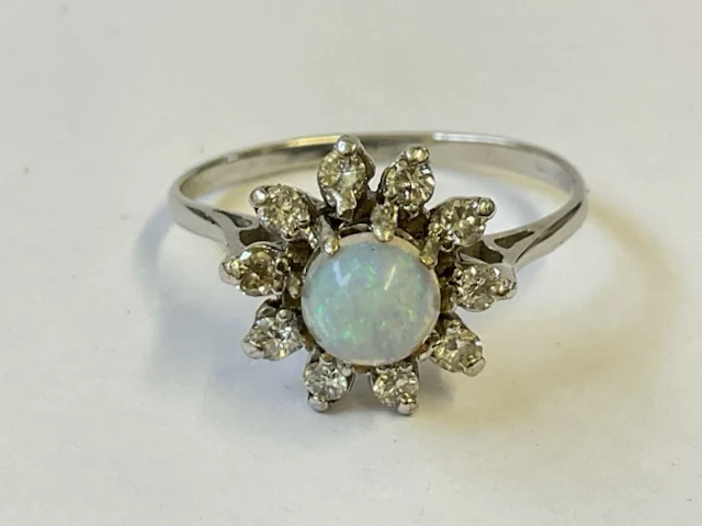 An antique 18ct white gold cluster ring claw set with central raised