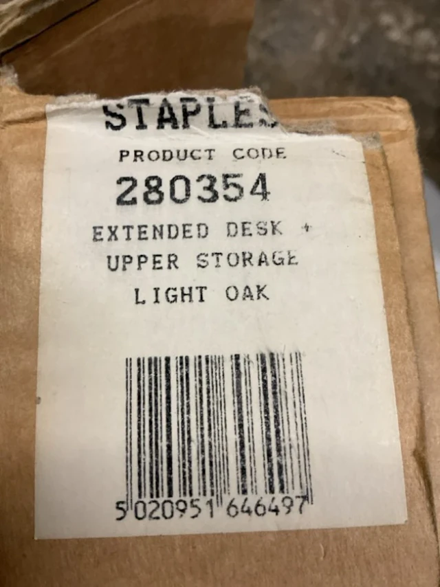 A boxed Staples light oak desk, the storage unit from the Home Office