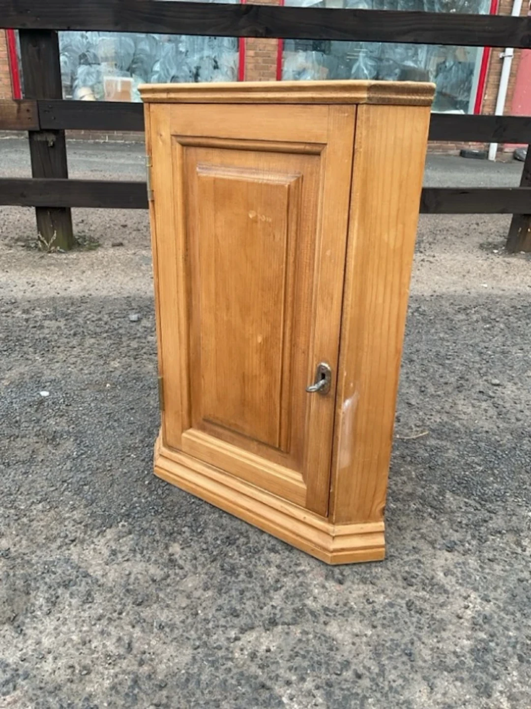 A small pine corner cabinet with fielded panelled door and interior