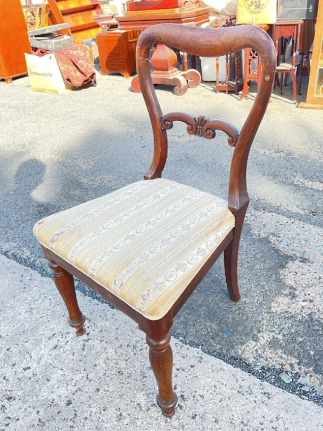 A Victorian rosewood chair with kidney shaped back and scroll carved