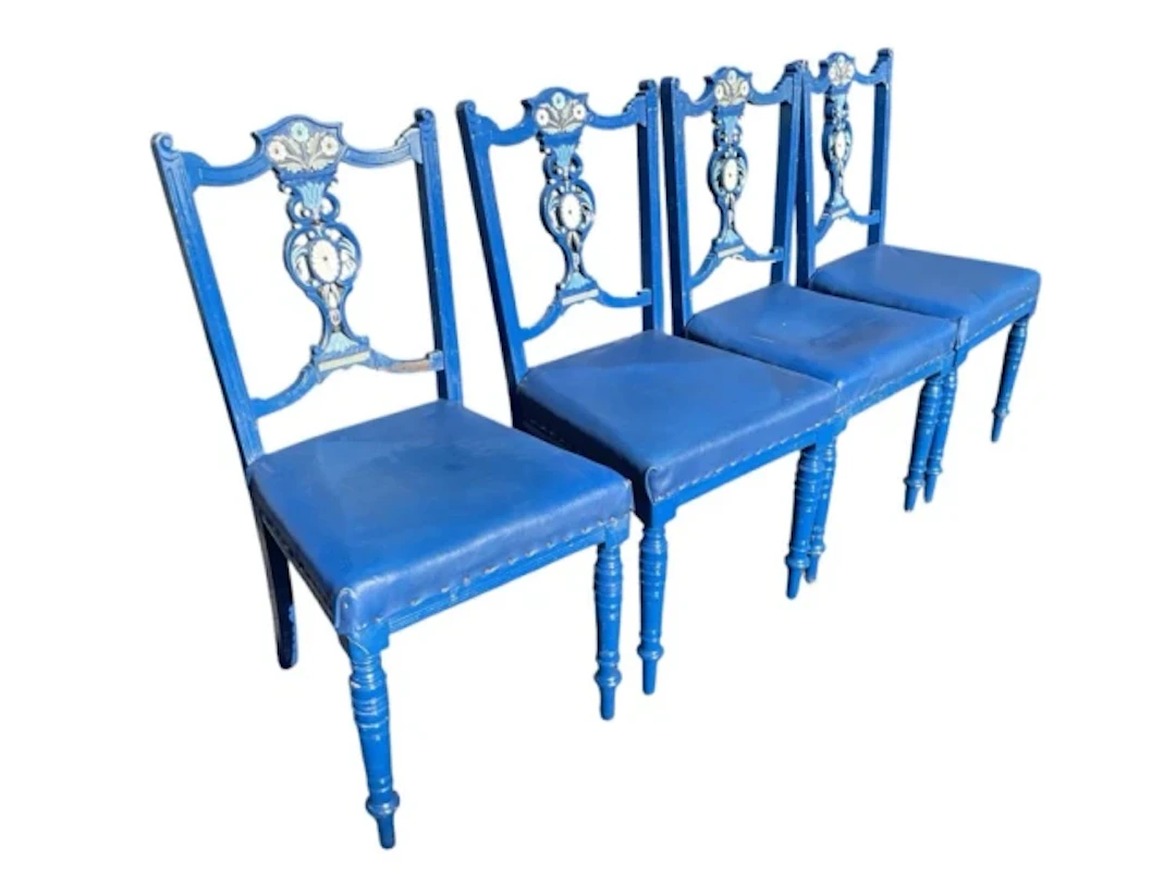 A set of four carved painted Edwardian chairs with floral pierced