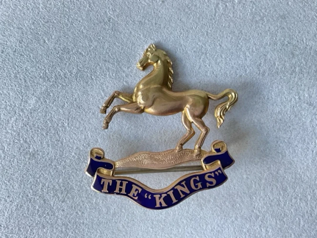 A 9ct gold sweetheart brooch for the Kings Regiment, with blue enamelled
